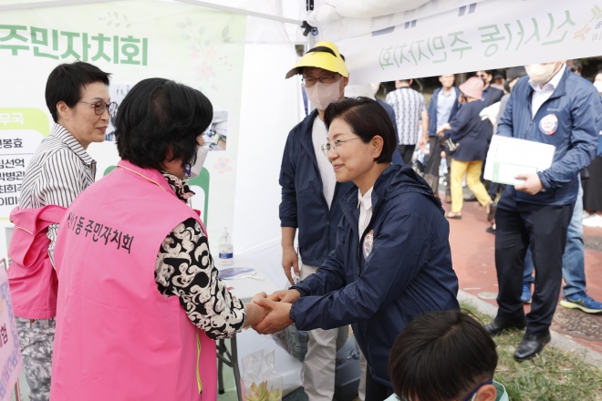 김미경(오른쪽) 은평구청장이 지난 1일 불광천에서 열린 주민자치회 어울림 한마당에 참석해 주민들을 만나 반갑게 악수하고 있다. 은평구 제공