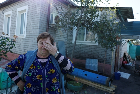 17일(현지시간) 러시아군 공격으로 마을 전체에 전기 및 가스 공급이 중단된 우크라이나 하르키우주 코로보치네에서 주민 올가(70)가 집 밖에서 눈물을 떨구고 있다. 2022.10.18  로이터 연합뉴스