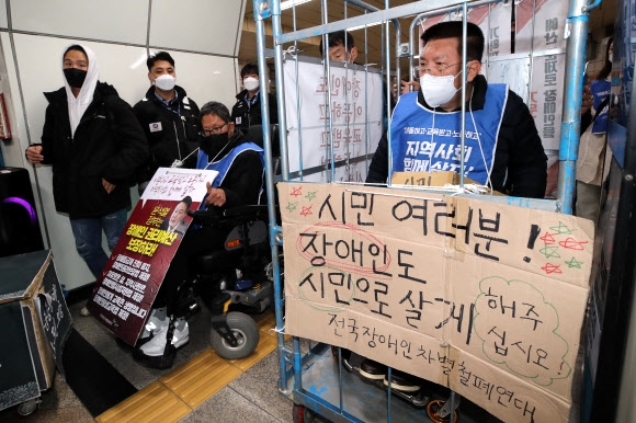 전국장애인차별철폐연대(전장연) 회원들이 25일 오전 서울 용산구 삼각지역에서 장애인권리예산 등을 촉구하는 ‘제41차 출근길 지하철 탑니다’ 시위를 하고 있다. 2022.10.25. 뉴시스