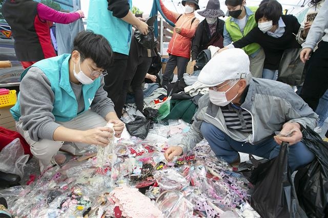 KT 강남서부광역본부가 제43회 흰지팡이의 날을 맞아 지난 13일 열린 ‘지역사회 사랑 나눔 축제’에 참여했다. 사진은 축제에 자원봉사자로 참여한 KT 사랑의봉사단원이 지역 주민에게 물품을 파는 모습. KT 제공