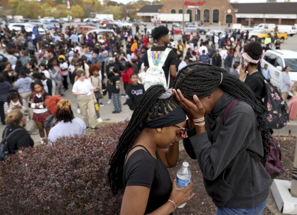 24일(현지시간) 미국 미주리주 세인트루이스의 한 고등학교에서 총기난사 사건이 일어난 뒤 학생들이 학교 근처 주차장에서 서로를 위로하고 있다. 2022.10.26 AP연합뉴스