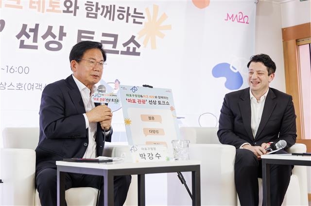 박강수(왼쪽) 서울 마포구청장이 지난 20일 합정동 한강변에 있는 잠두봉선착장에서 열린 ‘선상 토크쇼’에서 방송인 마크 테토와 마포의 관광 자원에 대해 이야기를 하고 있다. 마포구 제공