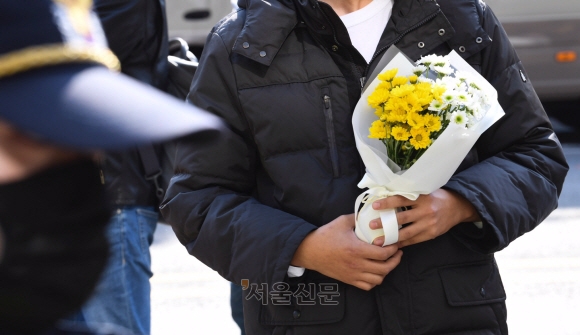 30일 오후 서울 용산구 이태원 압사 사고 현장 인근에 한 시민이 희생자를 추모하기 위해 꽃을 들고 있다. 2022.10.30. 오장환 기자