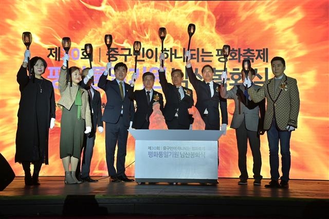 김길성(왼쪽 다섯 번째) 서울 중구청장이 지난 26일 중구 남산 팔각정과 봉수대에서 열린 ‘제30회 평화통일기원 남산봉화식’에서 참석자들과 통일을 염원하는 횃불을 밝히고 있다.  중구 제공 