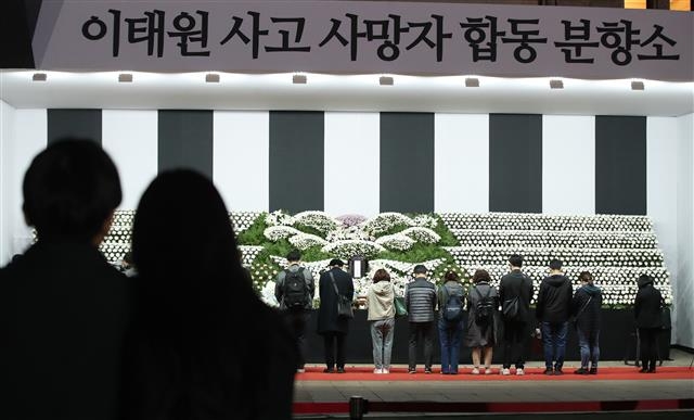 31일 오후 서울광장에 마련된 이태원 사고 사망자 합동분향소에서 시민들이 헌화 후 묵념을 하고 있다. 뉴스1