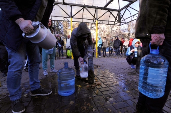지난달 31일(현지시간) 우크라이나 수도 키이우의 한 공공 수도펌프에서 시민들이 식수를 받기 위해 서있다. 러시아군의 공격으로 키이우 가구의 80%는 정전과 물 공급 중단을 겪고 있다. AFP 키이우 연합뉴스