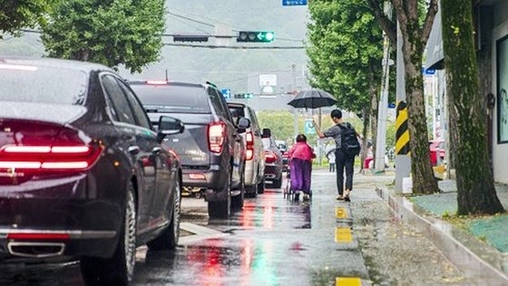 지난 9월 6일 김규민 학생이 구미역 뒷길에서 우산도 없이 비를 맞고 유모차를 끌고 가던 할머니에게 우산을 씌워주고 함께 걸어가는 모습. 경북문화신문 제공