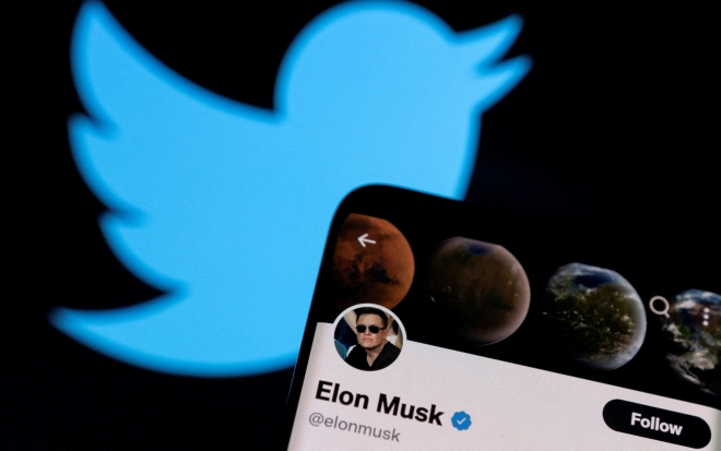 FILE PHOTO: A photo illustration shows Elon Musk‘s Twitter account and the Twitter logo