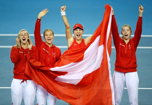 스위스 여자테니스 대표팀 선수들이 14일 빌리진킹컵 결승에서 호주를 제치고 첫 우승을 신고한 뒤 국기를 들고 환호하고 있다. [로이터 연합뉴스]