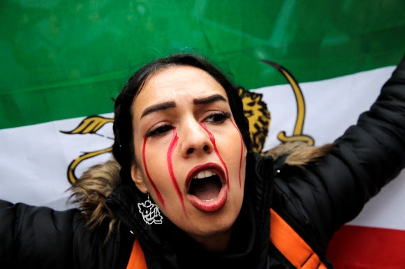 7일(현지시간) 터키 이스탄불 이란 영사관 앞에서 한 시위 참가자가 마흐사 아미니(22)의 사망에 항의하며 이란 여성인권 시위 구호를 외치고 있다. 이스탄불 로이터 연합뉴스