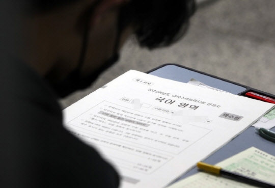 2023학년도 대학수학능력시험일인 17일 한 고등학교에 마련된 고사장에서 수험생들이 시험지를 받아들고 있다.  연합뉴스