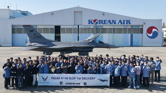 지난 18일 대한항공 부산 테크센터에서 직원들이 미 공군 F-16 수명연장사업의 초도 항공기 성공적 출고 기념 사진을 찍고 있다. 대한항공 제공