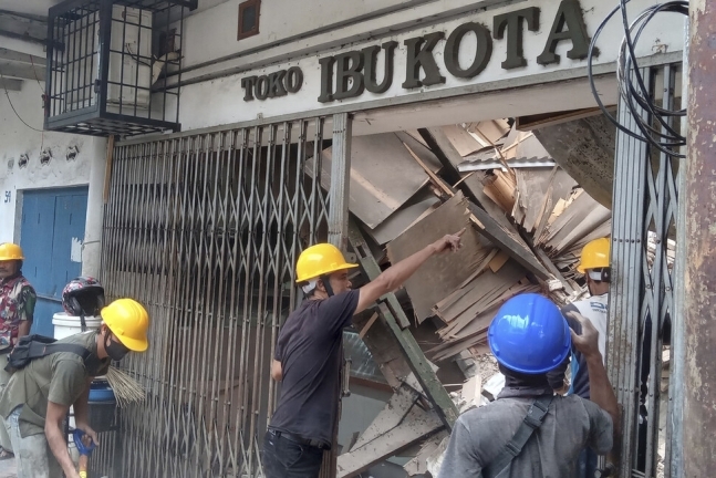 21일(현지시각) 인도네시아 서자바주 시안주르에서 발생한 지진으로 무너진 상점을 노동자들이 살펴보고 있다. 시안주르 AP 연합뉴스