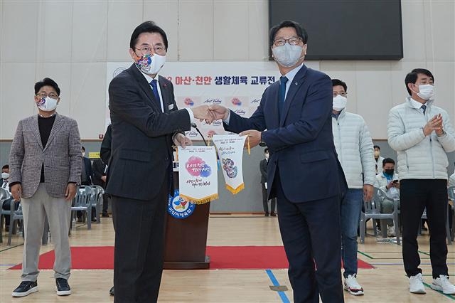 박경귀(왼쪽) 충남 아산시장과 신동헌 천안시 부시장이 지난 19일 생활체육교류전에 앞서 인사를 나누고 있다. 아산시 제공