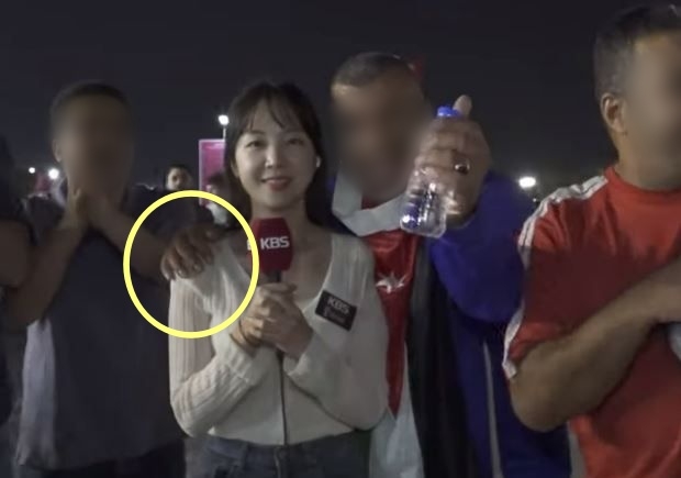 한 해외 축구팬이 20일(한국시각) 카타르에서 리포터 어깨에 손을 올리고 있는 모습. 유튜브 ‘이수날’ 캡처