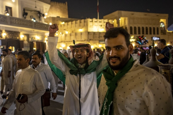 사우디아라비아 국기를 목에 두르거나 휘감은 팬들이 22일(현지시간) 카타르 도하의 유명 시장 수크 와키프에서 승리의 기쁨을 만끽하고 있다. 도하 EPA 연합뉴스 　