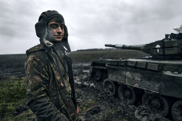 우크라이나 병사가 동부 도네츠크주 전선에서 노획한 러시아 T80 전차 옆에서 미소를 지어 보이고 있다. 2022.11.22 AP 연합뉴스