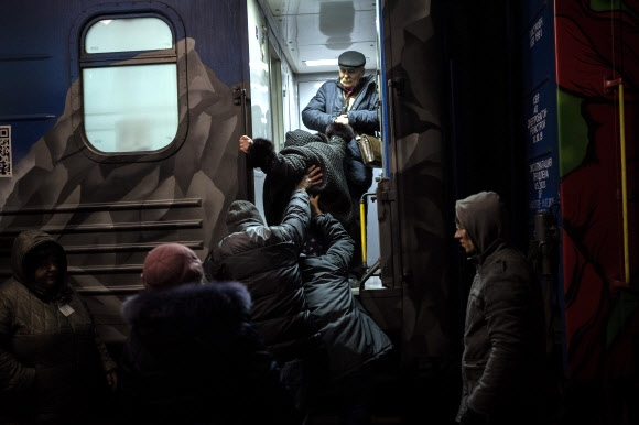 우크라이나 남부 헤르손 기차역에서 주민들이 키예프로 가는 열차에 탑승하고 있다. 우크라이나 당국은 최근 해방된 헤르손과 미콜라이우 지역에서 민간인들을 대피시키고 있다. 2022.11.21 AP 연합뉴스