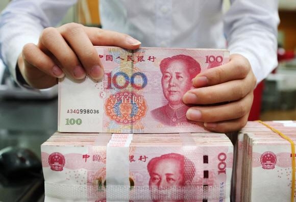 중국 장쑤성의 한 은행에서 행원이 100위안짜리 지폐를 세고 있다. 서울신문 DB
