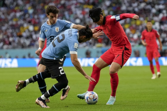 <yonhap photo-5724=“”> South Kore</yonhap> South Korea‘s Son Heung-min, right, is challenged by Uruguay’s Martin Caceres, center, Facundo Pellistri during the World Cup group H soccer match between Uruguay and South Korea, at the Education City Stadium in Al Rayyan , Qatar, Thursday, Nov. 24, 2022. (AP Photo/Alessandra Tarantino)/2022-11-24 22:27:45/ <연합뉴스