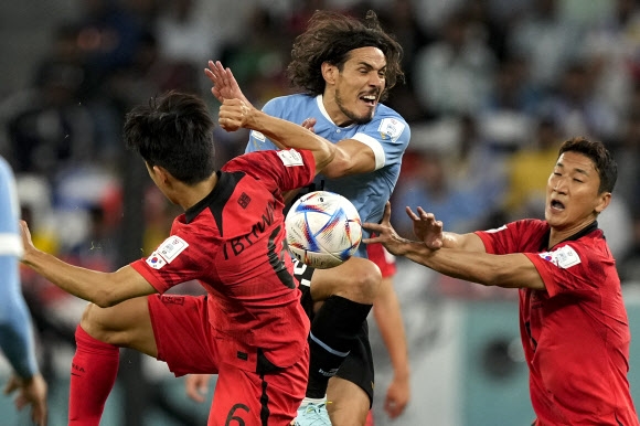 <yonhap photo-6255=“”> Uruguay‘s</yonhap> Uruguay‘s Edinson Cavani, center, fights for the ball with South Korea’s Hwang In-beom, left, and Jung Woo-young during the World Cup group H soccer match between Uruguay and South Korea, at the Education City Stadium in Al Rayyan , Qatar, Thursday, Nov. 24, 2022. (AP Photo/Martin Meissner)/2022-11-24 23:46:51/ <연합뉴스
