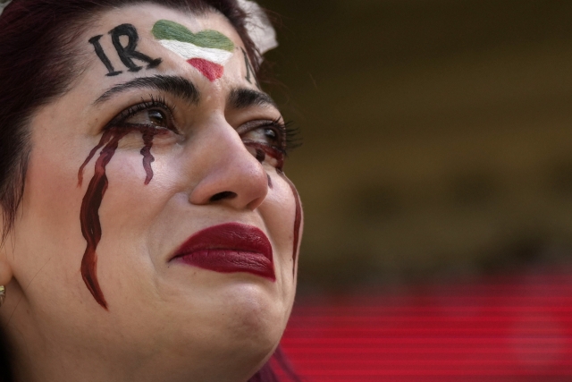 한 이란 여성이 자신의 얼굴에 이란 국기와 검은 피눈물을 그려 넣고 25일(현지시간) 카타르에서 열린 웨일스 대 이란 경기를 관람하고 있다. AP 연합뉴스