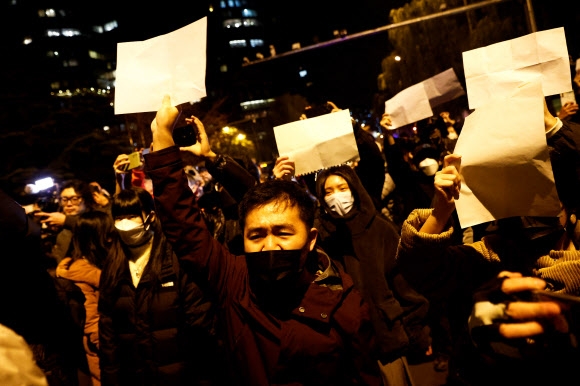 중국 베이징에서 시민들이 우루무치 화재 희생자를 추모하는 의미의 흰 종이를 들고 ‘제로 코로나’ 정책에 항의하는 시위를 벌이고 있다. 2022.11.27 로이터 연합뉴스