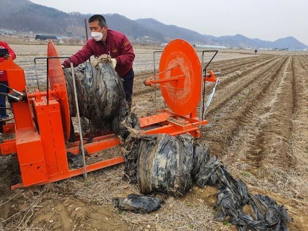 충북농업기술원이 개발한 트랙터 부착형 폐비닐 수거기로 폐비닐을 수거하는 모습. 충북도 제공