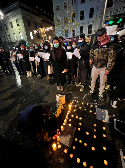 중국의 ‘제로 코로나’ 정책에 항의하는 ‘백지(白紙) 시위’를 지지하는 연대 시위가 세계 곳곳에서 벌어졌다. 아일랜드 수도 더블린에서도 중국계 시민들이 촛불 시위로 연대를 표시하고 있다.  더블린 로이터 연합뉴스