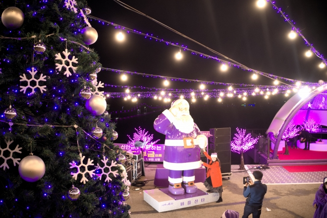퍼플섬으로 유명한 전남 신안군 반월·박지도에서 29일 퍼플 산타클로스와 퍼플 크리스마스트리 점등식 행사가 열렸다. 관광객들이 퍼플 산타크와 기념사진을 찍고 있다. 　신안군 제공 　