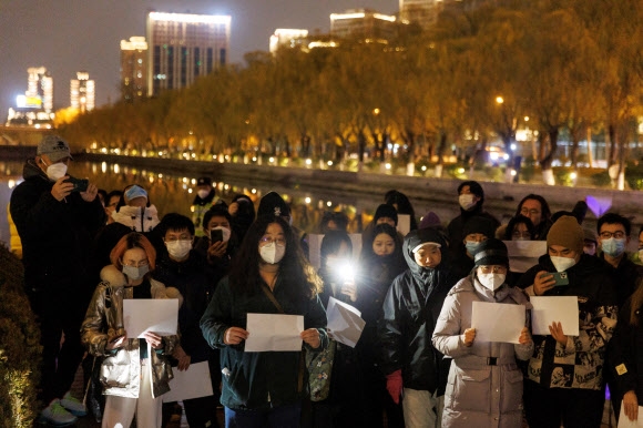 지난 27일 중국 베이징에서 시민들이 백지를 들고 행진하며 코로나19 봉쇄 조치에 반대하는 시위를 하고 있다. 로이터 연합뉴스