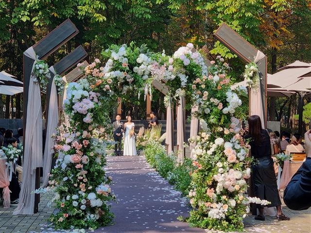 서울 동부공원 시민의숲 ‘꽃길결혼식’ 예식장에서 한 예비부부가 야외 결혼식을 올리고 있다.  서울시 제공