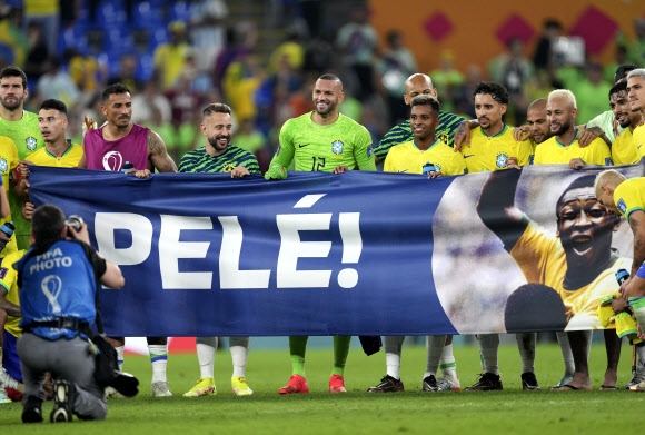 브라질 대표팀 선수들이 6일 새벽(한국시간) 카타르 도하 스타디움 974에서 열린 2022 카타르월드컵 한국과의 16강전에서 승리한 뒤 펠레의 쾌유를 기원하는 플래카드를 펼쳐 보이고 있다. 도하 신화 뉴시스