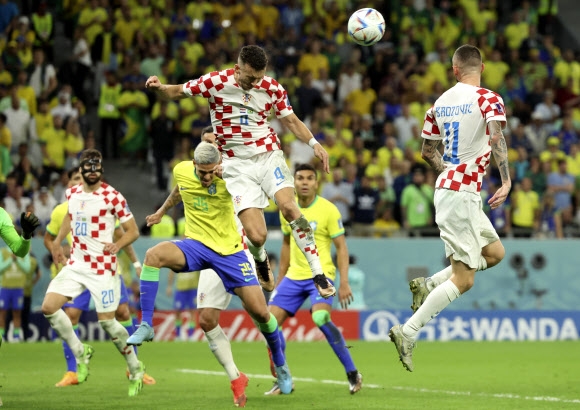 크로아티아의 이반 페리시치(가운데 위)가 지난 10일(한국시간) 카타르 알라이얀 에듀케이션 시티 스타디움에서 열린 카타르월드컵 8강전에서 브라질의 페드루와 공중볼 다툼을 벌이고 있다. 크로아티아는 브라질과 승부차기에서 4-2로 승리해 준결승에 진출했다. 알라이얀 신화 연합뉴스