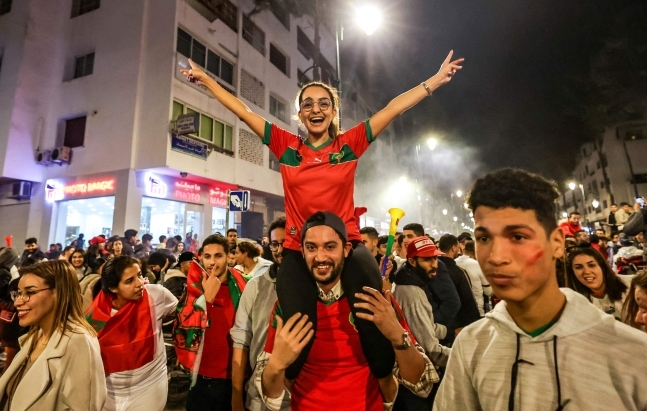 아프리카 국가 최초로 월드컵 4강 신화를 쓰자 모로코 국민들은 거리로 뛰쳐나와 환호했다. 사진은 모로코 수도 라바트에서 여성 축구팬이 남성의 목말을 탄 채 두 팔을 벌려 기뻐하는 모습. AFP 연합뉴스