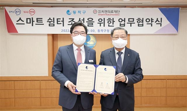 박일하(왼쪽) 동작구청장이 지난 7일 씨젠의료재단과 스마트 쉼터 조성을 위한 업무협약식을 한 후 기념촬영을 하고 있다. 동작구 제공