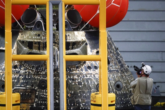 NASA의 오리온 캡슐이 2022년 12월 11일 멕시코 바하 캘리포니아 해안의 태평양에 낙하한 후 복구 작업 중 USS 포틀랜드의 우물 갑판으로 올려지고 있다. - 오리온은 달에 대한 25일간의 임무를 위해 아르테미스 로켓에 실려 11월 16일 발사되었다. 이 임무의 주요 목표는 오리온의 방열판을 시험하는 것이었습니다. - 사람이 타고 있는 날을 위한 것이지 마네킹이 안에 타는 것을 시험하는 것이 아니었다. (Photo by Mario Tama / POOL / AFP)/2022-12-12