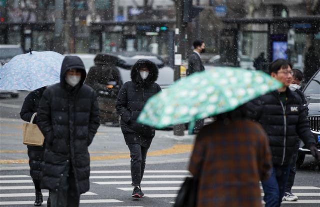 서울 등 수도권과 충청 지역에 눈이 내린 지난 6일 오전 서울 시내 한 거리에서 시민들이 눈을 맞으며 거리를 지나고 있다. 2022.12.6 뉴스1