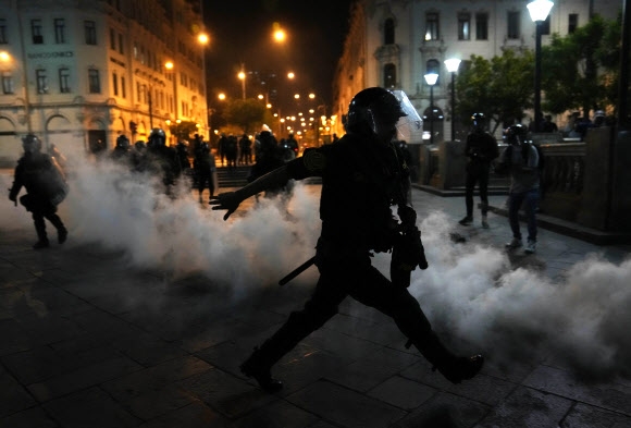 최루 가스가 살포된 페루 리마의 거리에서 11일(현지시간) 한 경찰이 페드로 카스티요 전 페루 대통령 지지자들의 반정부 시위를 해산하려 하고 있다. 리마 AP