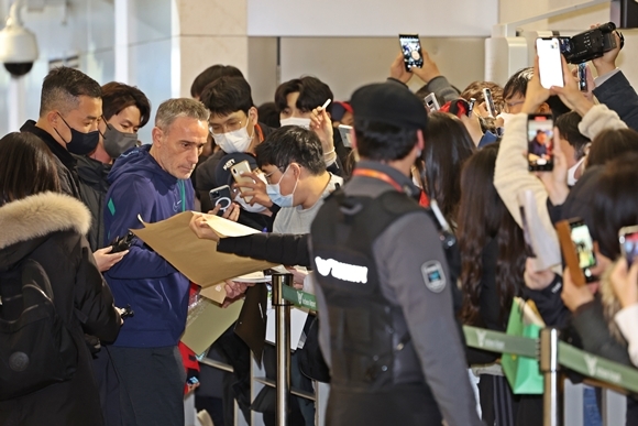 한국을 12년 만에 월드컵 본선 16강에 올린 파울루 벤투 감독이 13일 오후 인천국제공항을 통해 포르투갈로 출국하기에 앞서 팬들에게 사인을 해주고 있다. 2022.12.13  연합뉴스