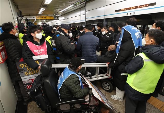 전국장애인차별철폐연대(전장연) 회원들이 14일 오전 서울 용산구 삼각지역에서 지하철 탑승 시위 도중 사다리 반입 시도로 경찰과 갈등을 빚고 있다. 이날 전장연 회원들의 지하철 내 사다리 반입 시도로 당고개 방면 열차 1대가 무정차 통과했다. 2022.12.14 뉴스1