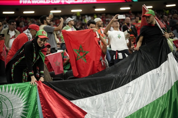 모로코 서포터들이 15일(한국시간) 알코르의 알바이트 스타디움에서 열리는 프랑스와의 2022 카타르월드컵 준결승 응원석 난간에 팔레스타인 국기를 내걸고 있다. 알코르 AP 연합뉴스 