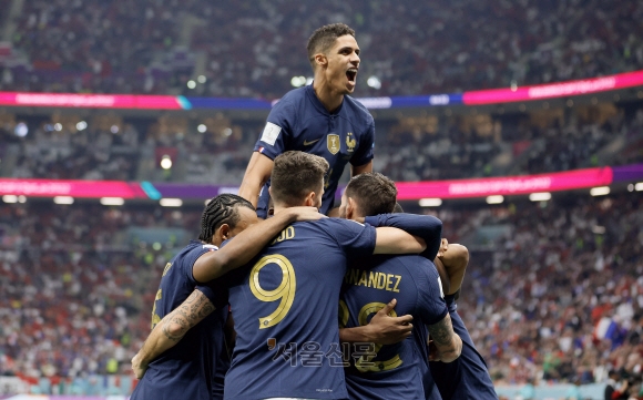 라파엘 바란(위)이 2022년 12월 14일 카타르 알코르의 알베이트 스타디움에서 열린 프랑스와 모로코의 2022년 FIFA 월드컵 준결승전에서 테오 에르난데스(앞-R)가 1-0으로 득점한 뒤 동료들과 함께 기뻐하고 있다.  EPA/Ronald Wittek