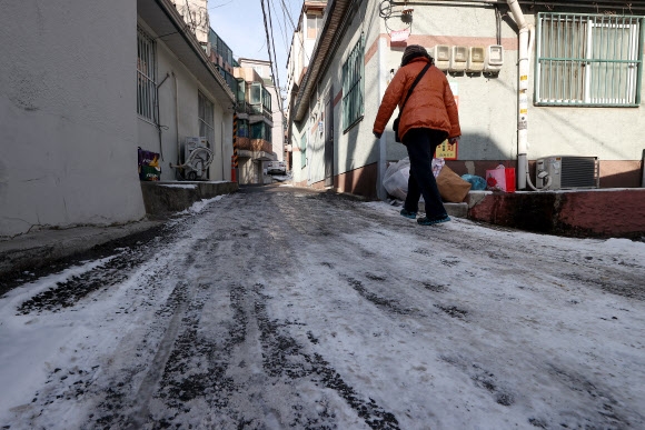 16일 오후 서울 용산구청 인근 주택가에서 한 시민이 눈이 녹지 않은 이면도로에서 이동하고 있다. 2022.12.16 연합뉴스 