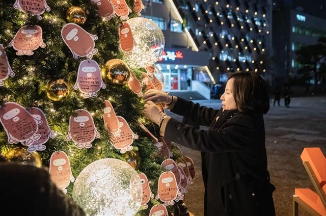 이수희 서울 강동구청장이 지난 13일 구청 열린 뜰에 설치된 ‘힘찬 변화, 자랑스러운 강동 트리’를 찾아 ‘함께 만드는 희망 메시지’ 이벤트에 참여하고 있다. 강동구 제공