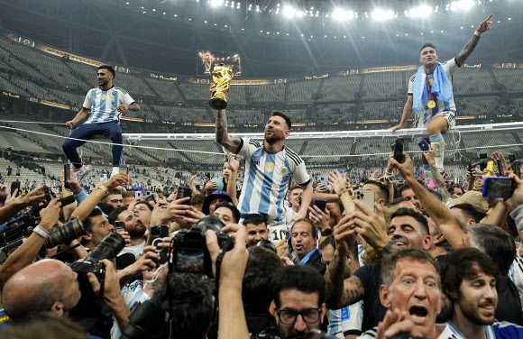 2022 카타르 월드컵에서 우승한 아르헨티나의 리오넬 메시와 동료들이 18일(현지시간) 카타르 루사일 경기장에서 트로피를 들고 승리의 기쁨을 만끽하고 있다. 2022.12.18 AP 연합뉴스