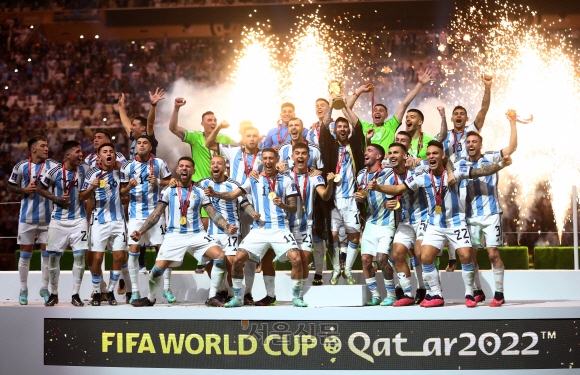 Soccer Football - FIFA World Cup Qatar 2022 - Final - Argentina v France - Lusail Stadium, Lusail, Qatar - December 18, 2022 Argentina‘s Lionel Messi celebrates with the trophy and teammates after winning the World Cup REUTERS/Carl Recine     TPX IMAGES OF THE DAY/2022-12-19 05:52:28/ <저작권자 ⓒ 1980-2022 ㈜연합뉴스. 무단 전재 재배포 금지.>