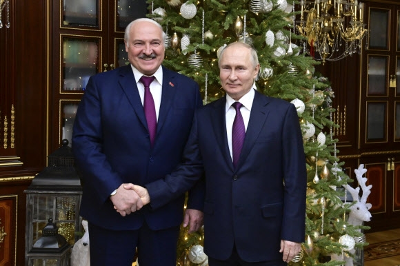 블라디미르 푸틴(오른쪽) 러시아 대통령이 알렉산드르 루카셴코 벨라루스 대통령과 19일(현지시간) 벨라루스 민스크에서 열린 정상회담 후 기념 사진을 촬영하고 있다. 민스크 스푸트니크 AP
