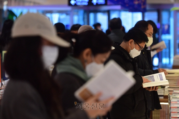 실내에서도 마스크 착용 의무를 완화하는 방안이 검토되고 있는 가운데 21일 서울 종로구 교보문고에서 마스크를 쓴 시민들이 책을 고르고 있다. 홍윤기 기자