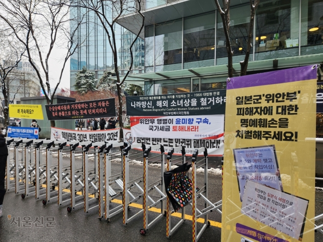정의기억연대가 주최한 정기 수요집회가 열린 21일 서울 종로구 평화의 소녀상 인근 집회 현장 맞은편에 보수단체가 설치한 2차 가해 현수막이 게시돼있다. 곽소영 기자